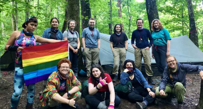a group of teens pose for a photo at a campsite on an outward bound course for lgbtq teens